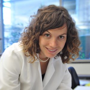 Woman wearing lab coat, smiling
